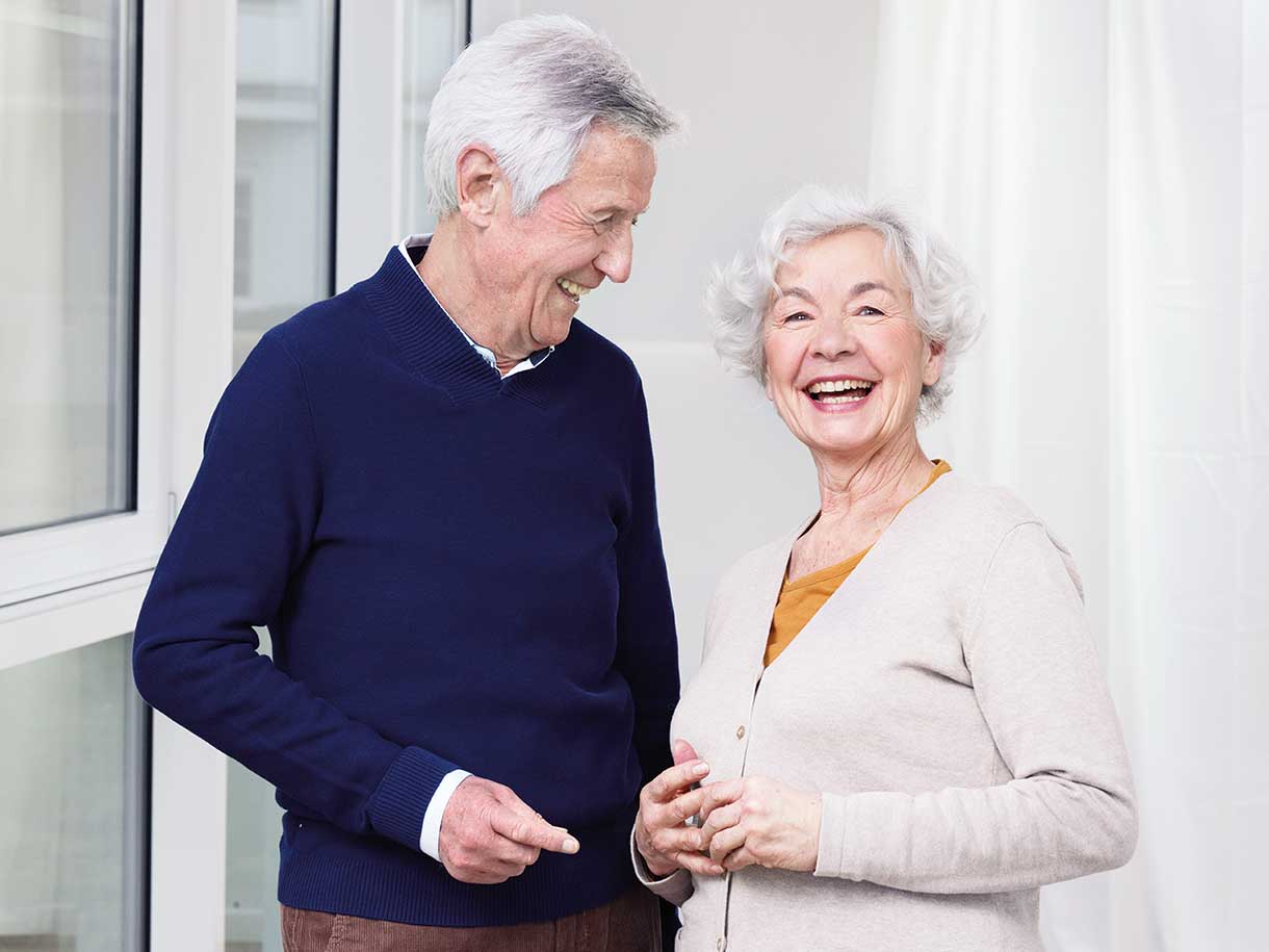 Yaşlı bir adam ve yaşlı bir kadın birlikte gülümsüyor